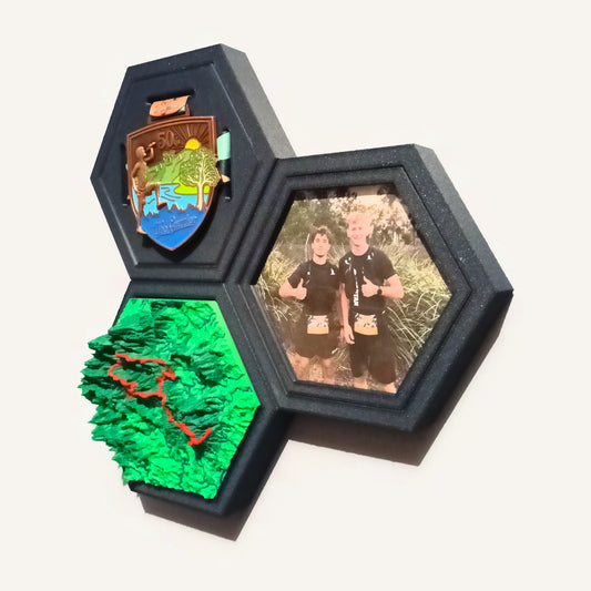 A Photo Tile hung edge to edge with a Medal Tile and a green Terrain Tile, in Navy frames