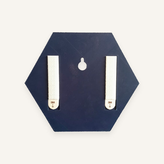 Back of a Navy backpiece with two adhesive hanging strips and a keyhole